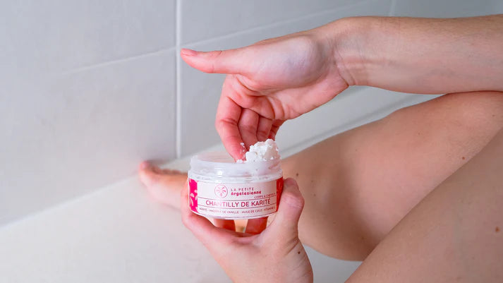 Texture onctueuse de la chantilly de karité naturelle, prélevée avec le doigt pour le soin du corps